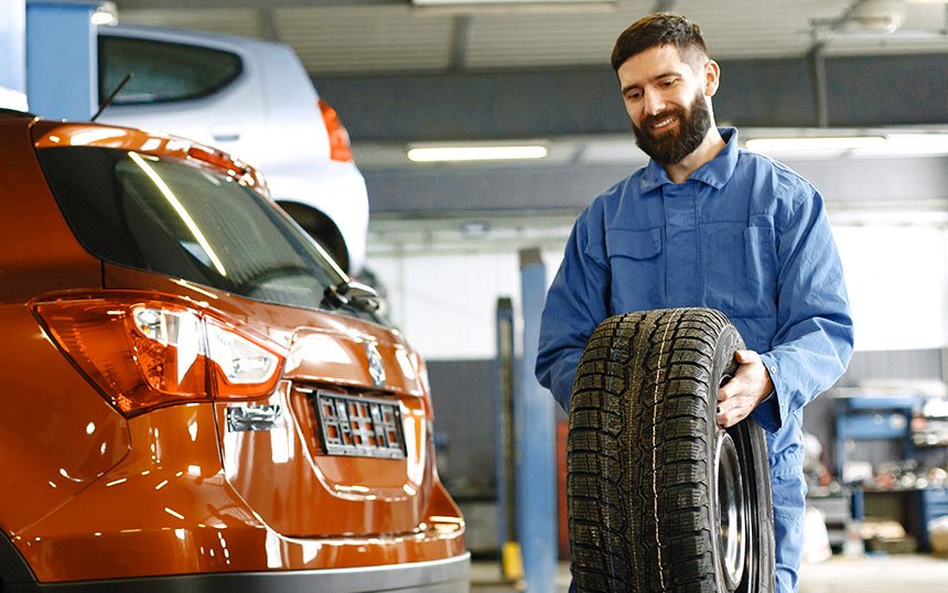 Mechanic Carrying a Wheel Mechanic Carrying a Wheel